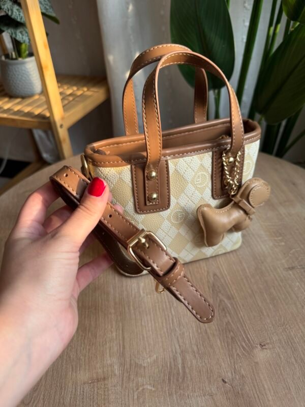 حقيبة مع مداليه لونها اوف وايت مطعم بني